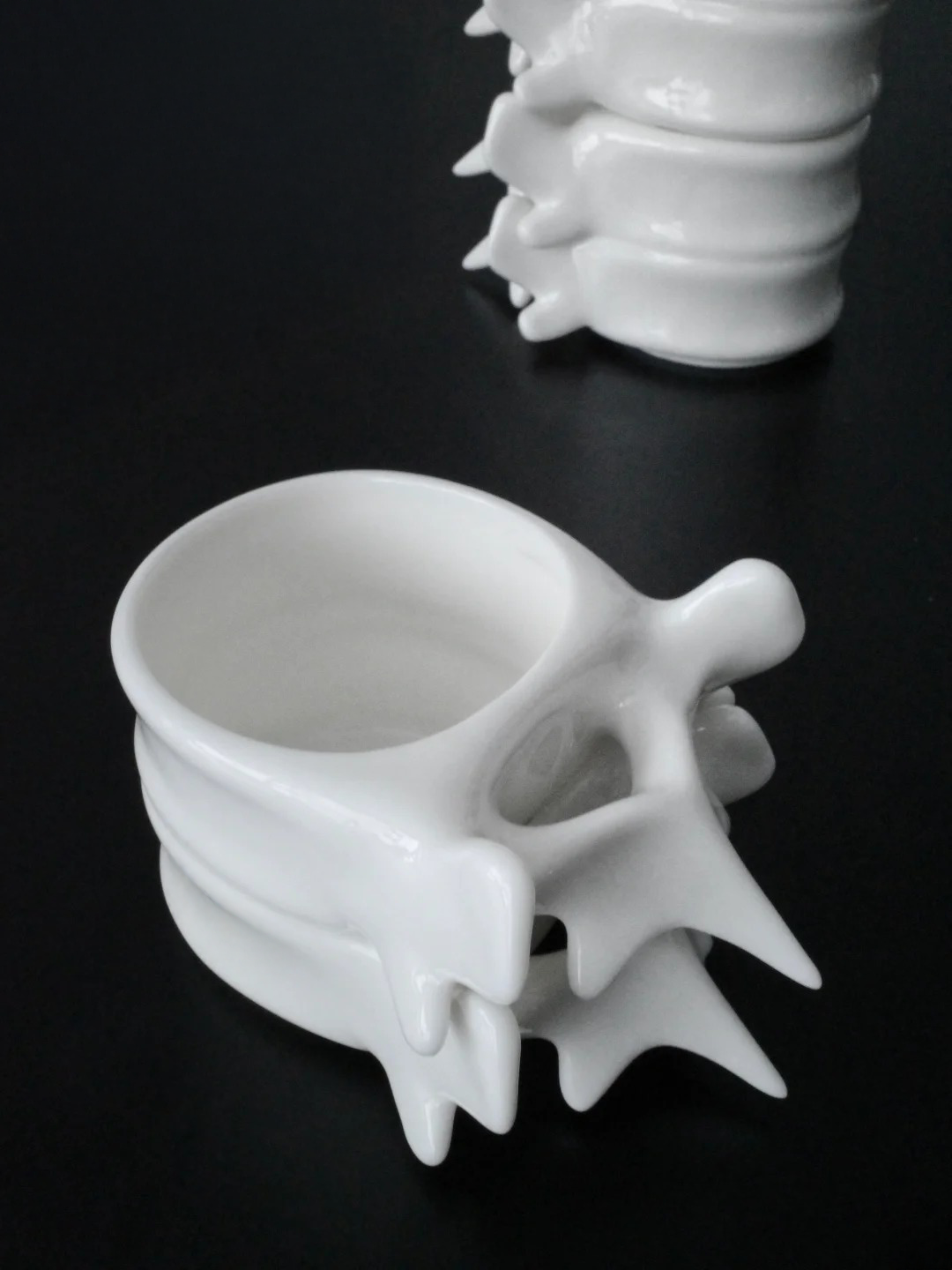 White porcelain Spine Cup with a second cup partially visible behind it