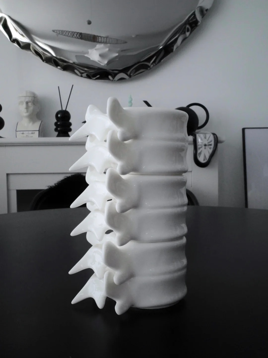 A vertical stack of white porcelain Spine Cups in an interior setting