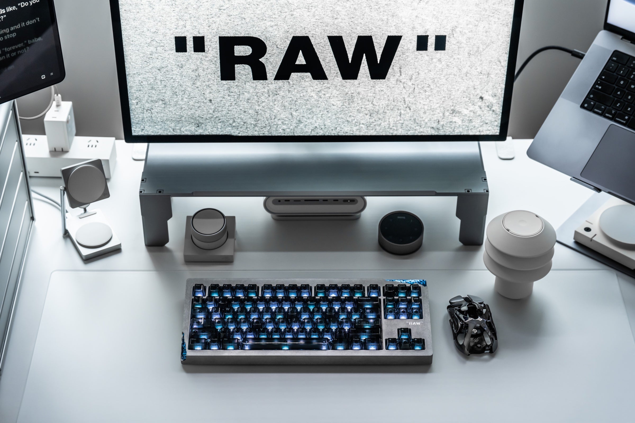 AM Relic 80 RAW keyboard with blue lighting in a white multi-monitor desktop setup.
