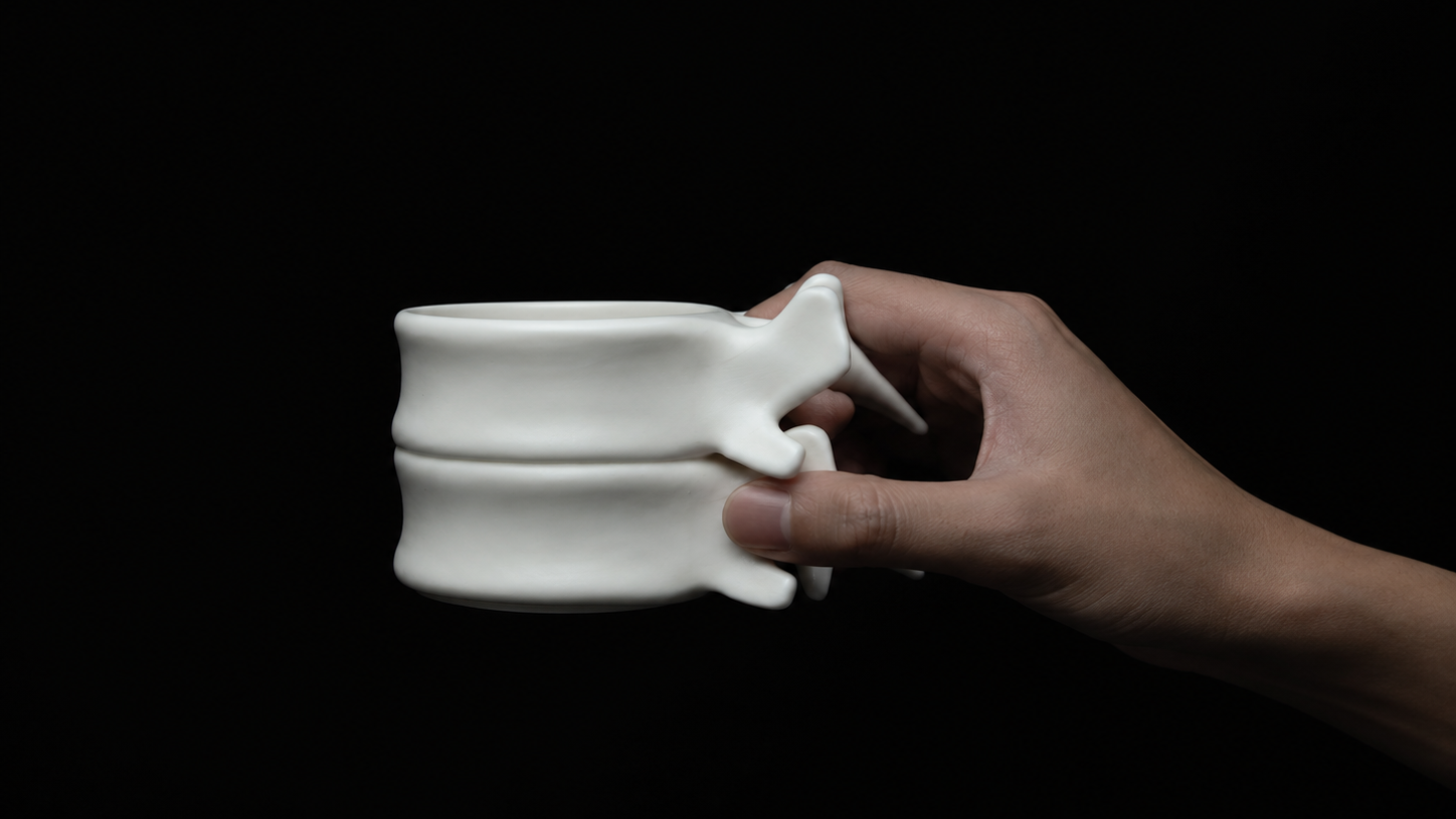 Hand holding the white porcelain Spine Cup