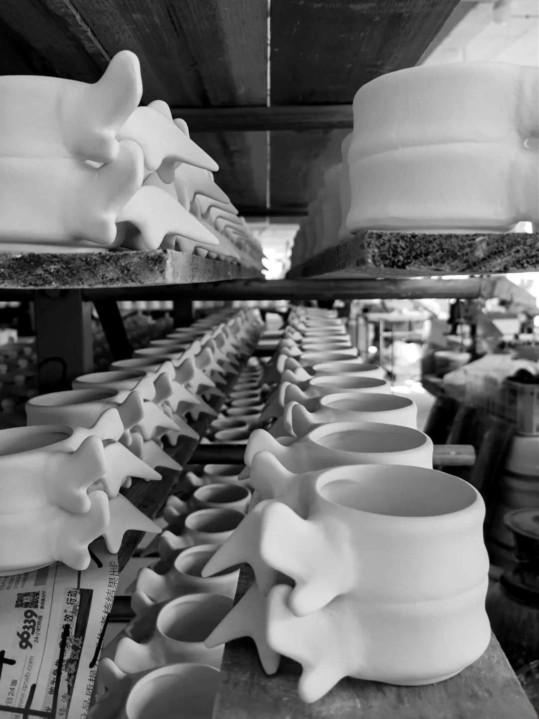Rows of glazed Spine Cups drying on workshop racks