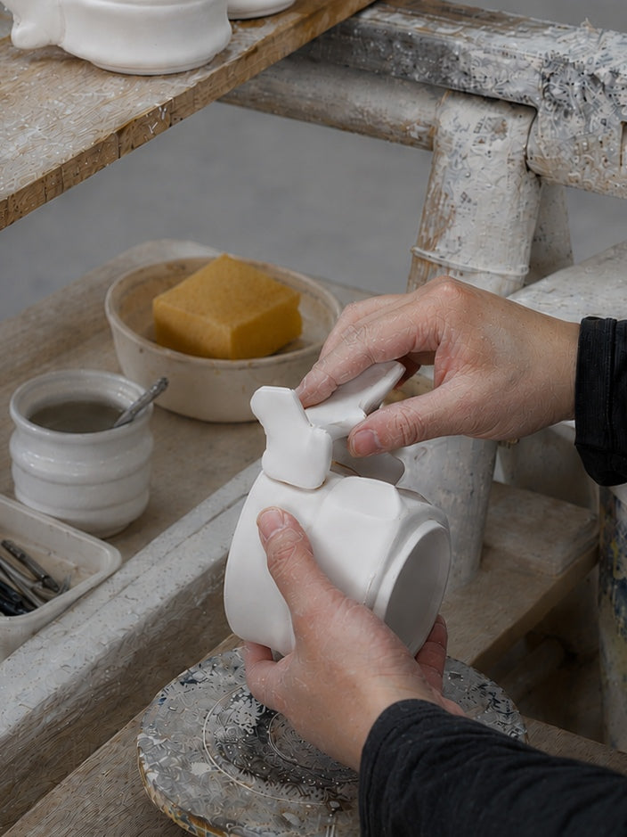 Craftsperson joining a porcelain vertebral component to the cup
