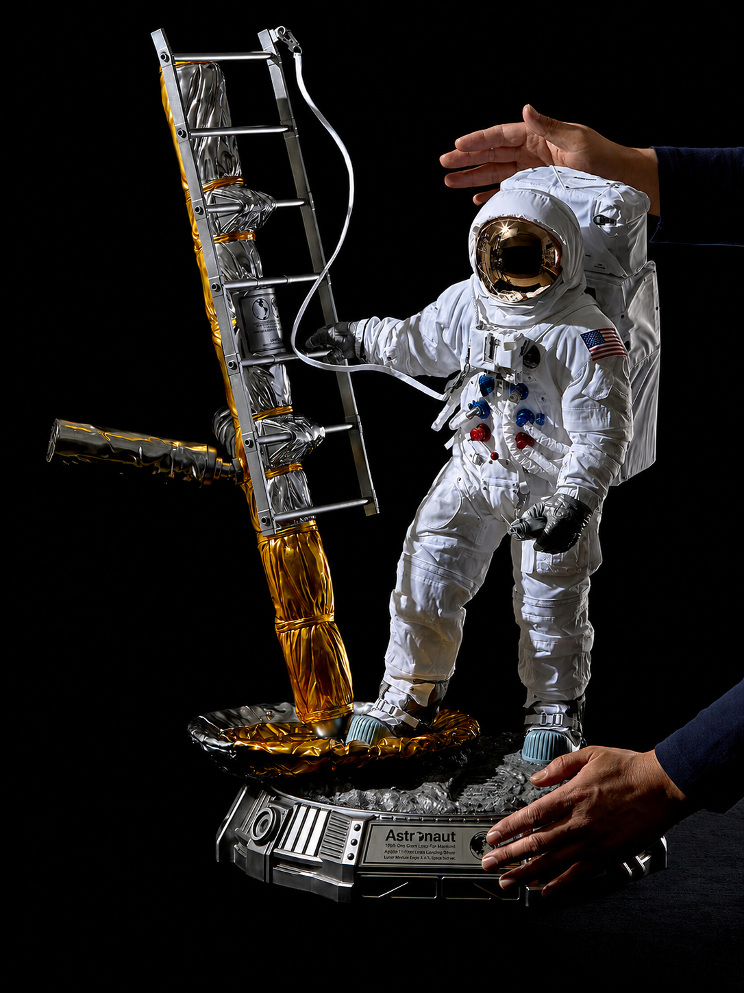Full sculpture shown between two hands to demonstrate its display scale.